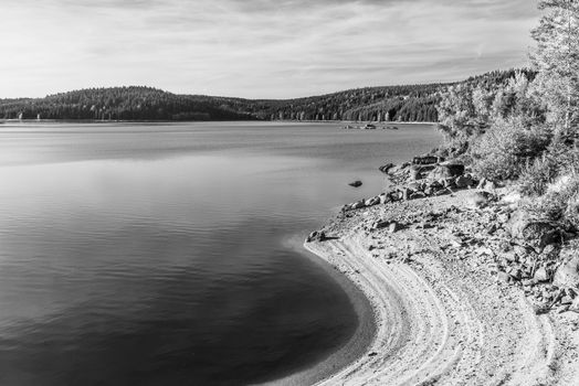 Mountain water reservoir Josefuv Dul, aka Josefodolska Dam, Jizera Mountains, Czech Republic. Sunny summer day. Black and white image.