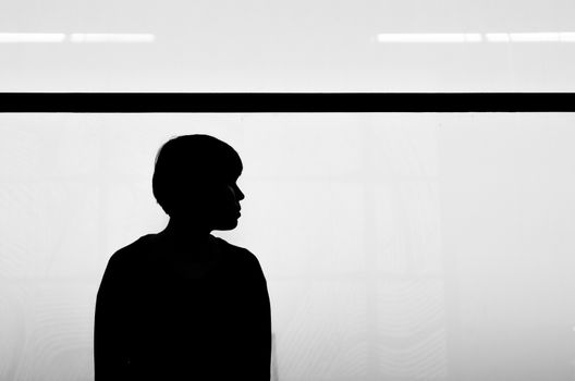 The silhouette of a woman stands under a black horizontal line