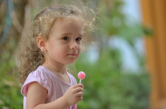 Little girl with lollipop in nature