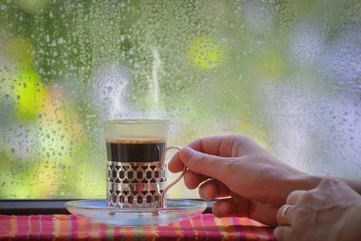 Fresh turkish coffee cup at rainy window