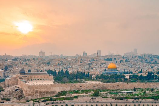 Panoramic view of Jerusalem old city and the Temple Mount during a dramatic colorful sunset. A view of the Dome of the Rock and Al Aqsa Mosque from the Mount of Olives in Jerusalem, Israel.