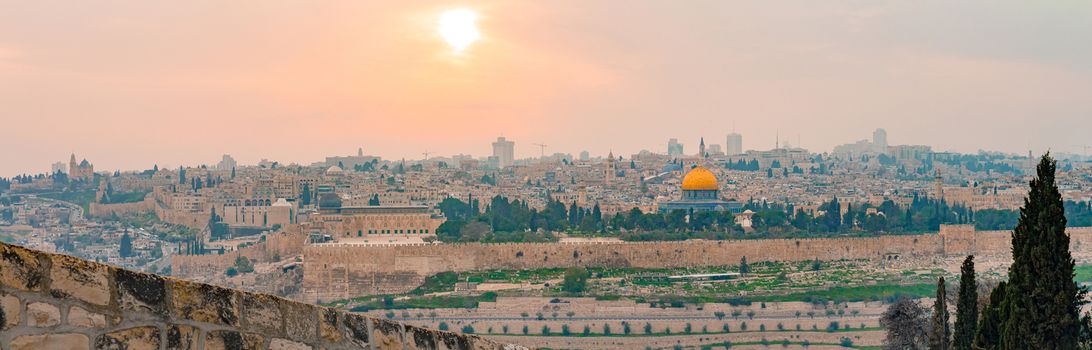 Panoramic view of Jerusalem old city and the Temple Mount during a dramatic colorful sunset. A view of the Dome of the Rock and Al Aqsa Mosque from the Mount of Olives in Jerusalem, Israel.