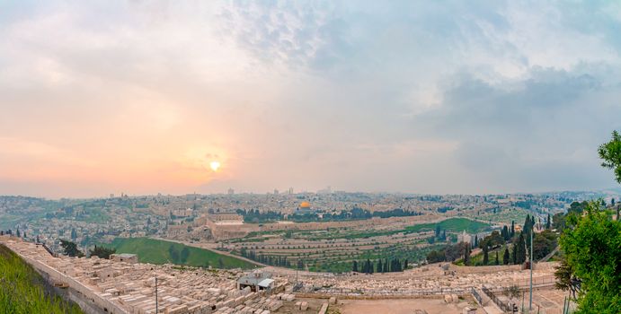Panoramic view of Jerusalem old city and the Temple Mount during a dramatic colorful sunset. A view of the Tomb of the Prophets, Dome of the Rock and Al Aqsa Mosque from the Mount of Olives in Jerusalem, Israel.