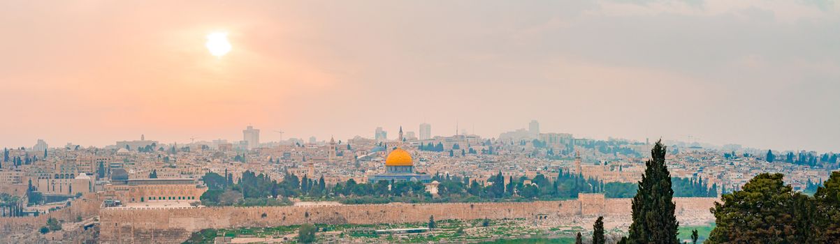 Panoramic view of Jerusalem old city and the Temple Mount during a dramatic colorful sunset. A view of the Dome of the Rock and Al Aqsa Mosque from the Mount of Olives in Jerusalem, Israel.