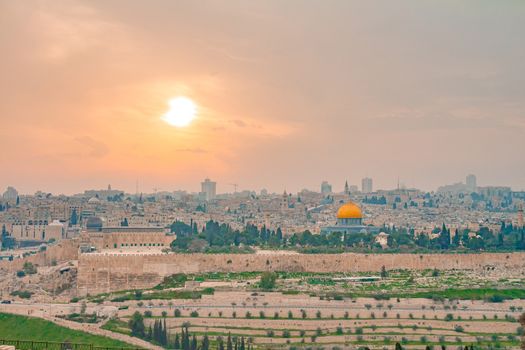 Panoramic view of Jerusalem old city and the Temple Mount during a dramatic colorful sunset. A view of the Dome of the Rock and Al Aqsa Mosque from the Mount of Olives in Jerusalem, Israel.