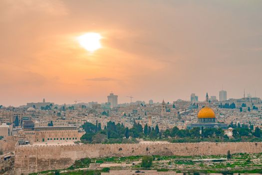 Panoramic view of Jerusalem old city and the Temple Mount during a dramatic colorful sunset. A view of the Dome of the Rock and Al Aqsa Mosque from the Mount of Olives in Jerusalem, Israel.