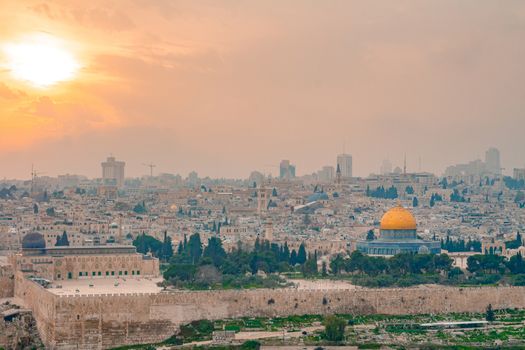 Panoramic view of Jerusalem old city and the Temple Mount during a dramatic colorful sunset. A view of the Dome of the Rock and Al Aqsa Mosque from the Mount of Olives in Jerusalem, Israel.
