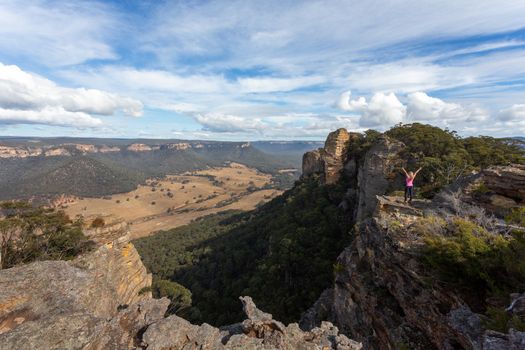 Adventurous hiker reaching the top slab of Donkey Mountain with spectacular views over the valley and mountain escarpment  below