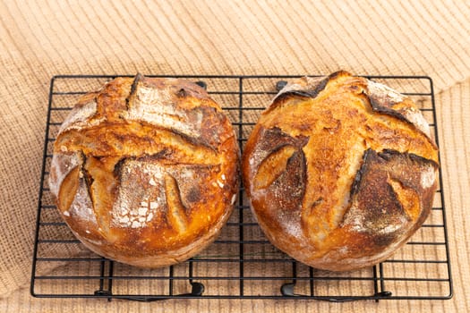 Freshly baked artisan sourdough bread loaves on jute fabric.