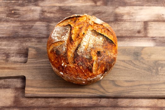 Freshly baked artisan sourdough bread loaf on a wooden board.