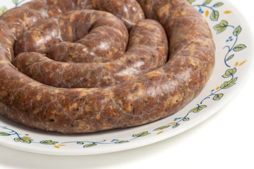 Homemade stuffed pork sausages in a a plate isolated on white.