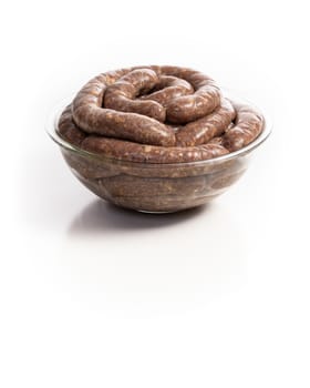 Homemade stuffed pork sausages in a glass bowl isolated on a white background, with copyspace.