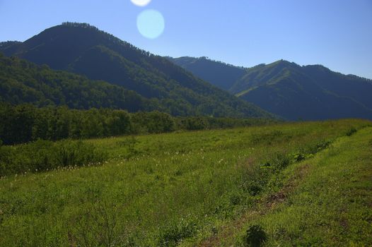 Fertile valley and pasture surrounded by mountains. Altai, Siberia, Russia