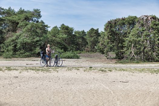 Otterlo,Netherlands,24-june-2019:woman on a bike in national park the hooge veluwe in holland, the park is famous of its wild deers and eautifull landscape