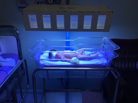 Newborns in incubators. blue light