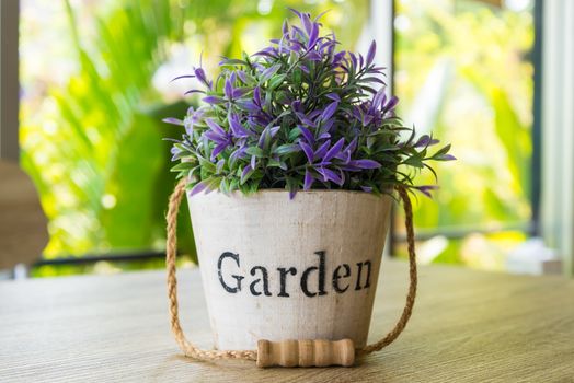 Purple flower pots placed on a wooden table.