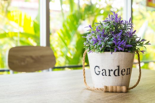 Purple flower pots placed on a wooden table.