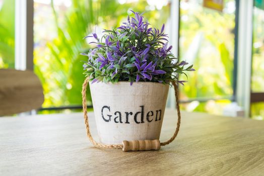 Purple flower pots placed on a wooden table.