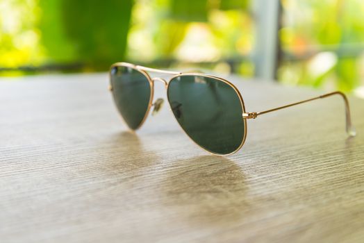 Sunglasses resting on a wooden table.