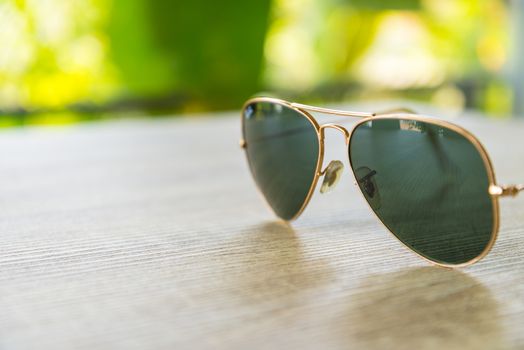 Sunglasses resting on a wooden table.