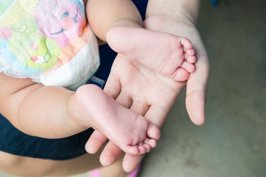 Baby feet in mother's hands, concept of love and family,sensitive focus