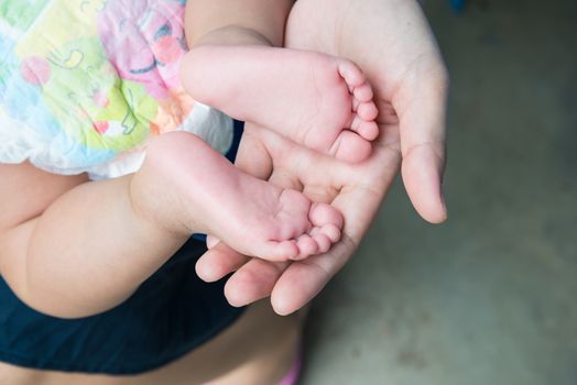 Baby feet in mother's hands, concept of love and family,sensitive focus