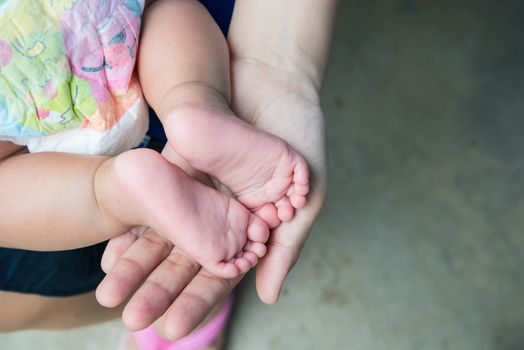 Baby feet in mother's hands, concept of love and family,sensitive focus