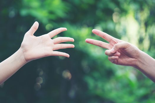 Couple play rock paper scissors hand game nature green background