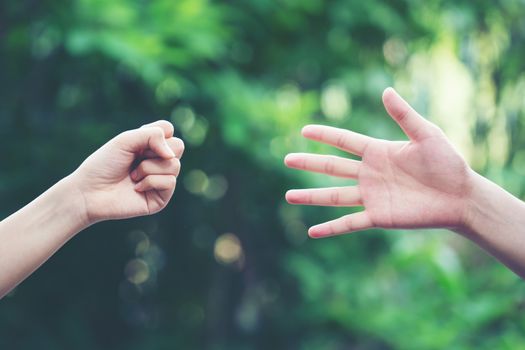 Couple play rock paper scissors hand game nature green background