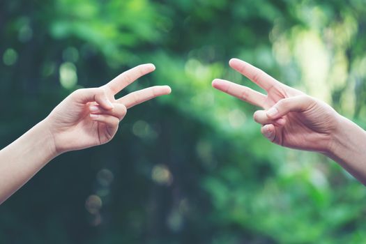 Couple play rock paper scissors hand game nature green background