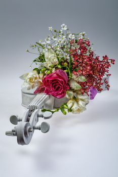 Bouquet of flowers and violin on a studio background