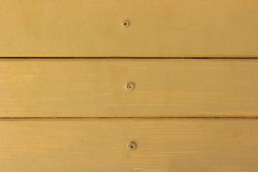 wooden wall with nails and paint by yellow color.