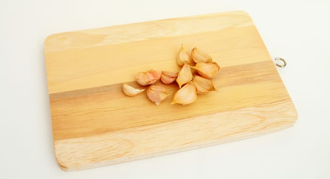 pieces of garlics on chopping Board.