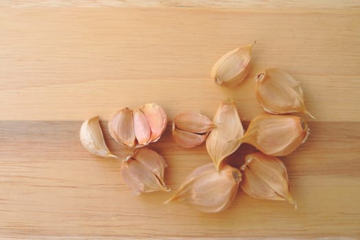 pieces of garlic on wooden background.