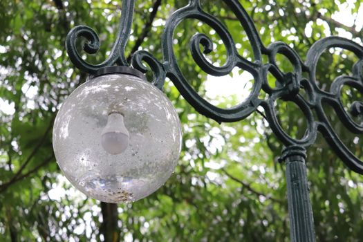 Spherical vintage designer streetlamp in the greenery of park