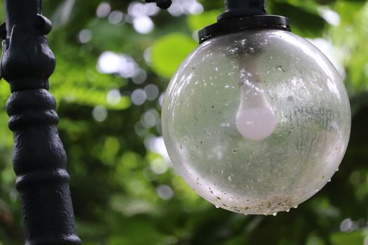 Spherical vintage designer streetlamp in the greenery of park