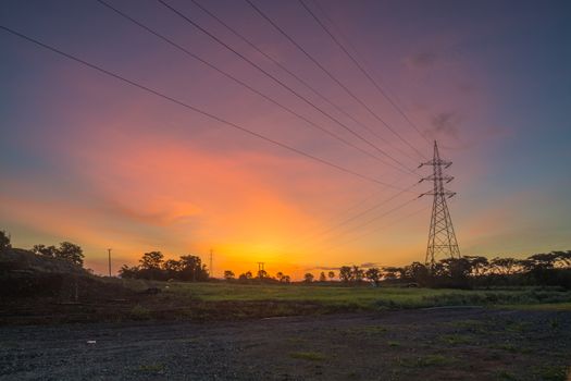 Electric Tower with Cable against Twilight Sky with blue, orange and red Color.