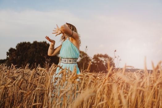 Beautiful Young Woman Dancing In The Field at sunset