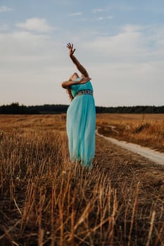 Beautiful Young Woman Dancing In The Field at sunset