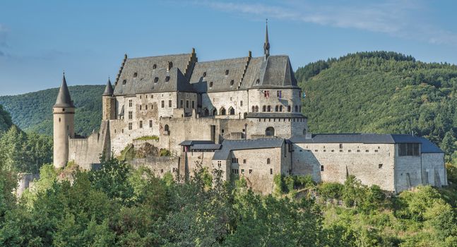 The old and restored Vianden castle on a blue sky background , Luxembourg, Europe