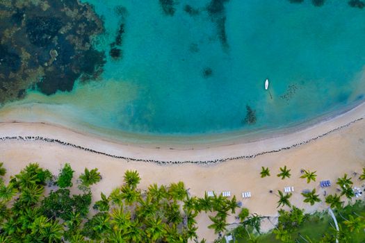 Aerial view of tropical beach with white boat anchored.Samana peninsula,El Portillo beach,Dominican Republic.