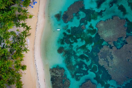 Drone shot of tropical beach with white boat anchored.Samana peninsula,Bahia Principe beach,Dominican Republic.