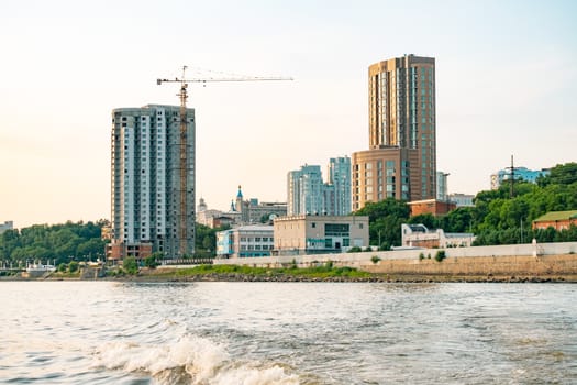 View of the city of Khabarovsk from the Amur river. Urban landscape in the evening at sunset