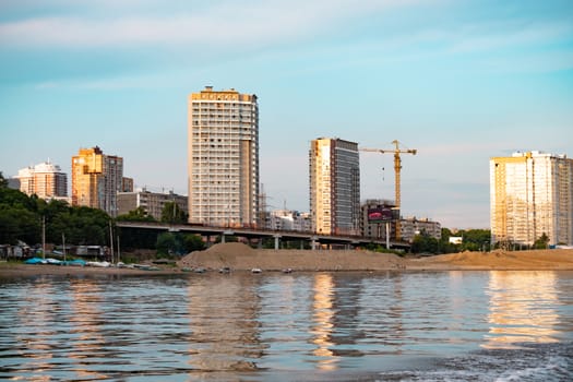 View of the city of Khabarovsk from the Amur river. Urban landscape in the evening at sunset