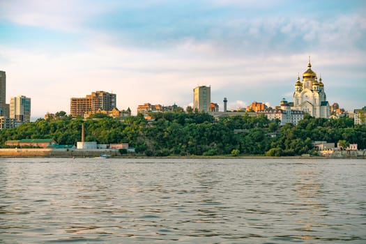 View of the city of Khabarovsk from the Amur river. Urban landscape in the evening at sunset