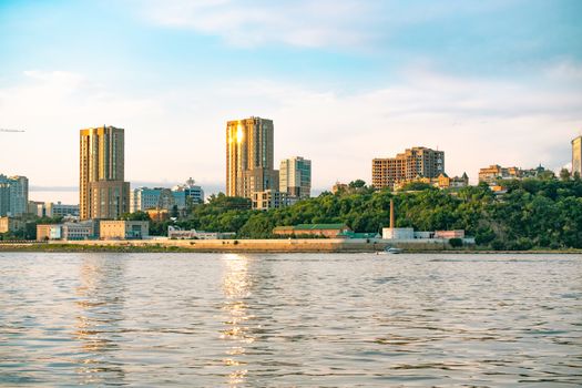 View of the city of Khabarovsk from the Amur river. Urban landscape in the evening at sunset