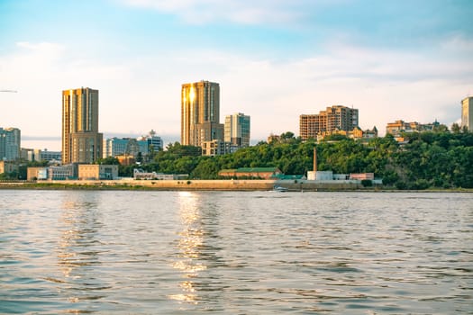 View of the city of Khabarovsk from the Amur river. Urban landscape in the evening at sunset