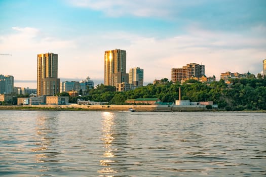 View of the city of Khabarovsk from the Amur river. Urban landscape in the evening at sunset