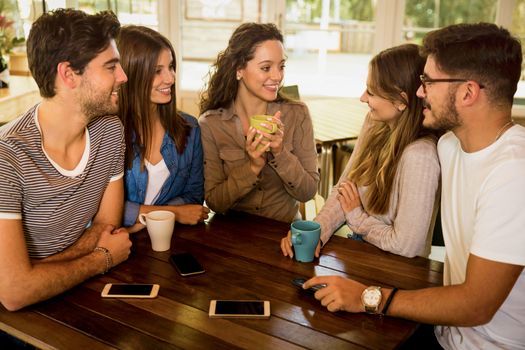 A group of friends talking and drinking coffee at the cafe