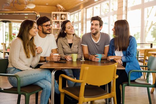 A group of friends talking and drinking coffee at the cafe